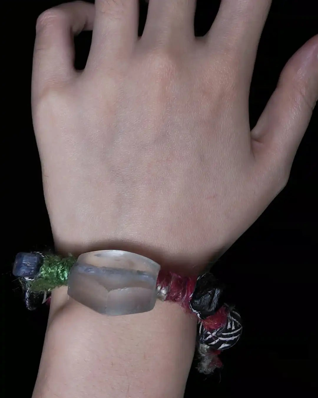 The Shaman #10 multi-stone bracelet by à la luck — worn on the wrist showing the oversized Himalayan weathered glass bead focal flanked by third-eye black agate and African clay bead on Nepali banana silk yarn.