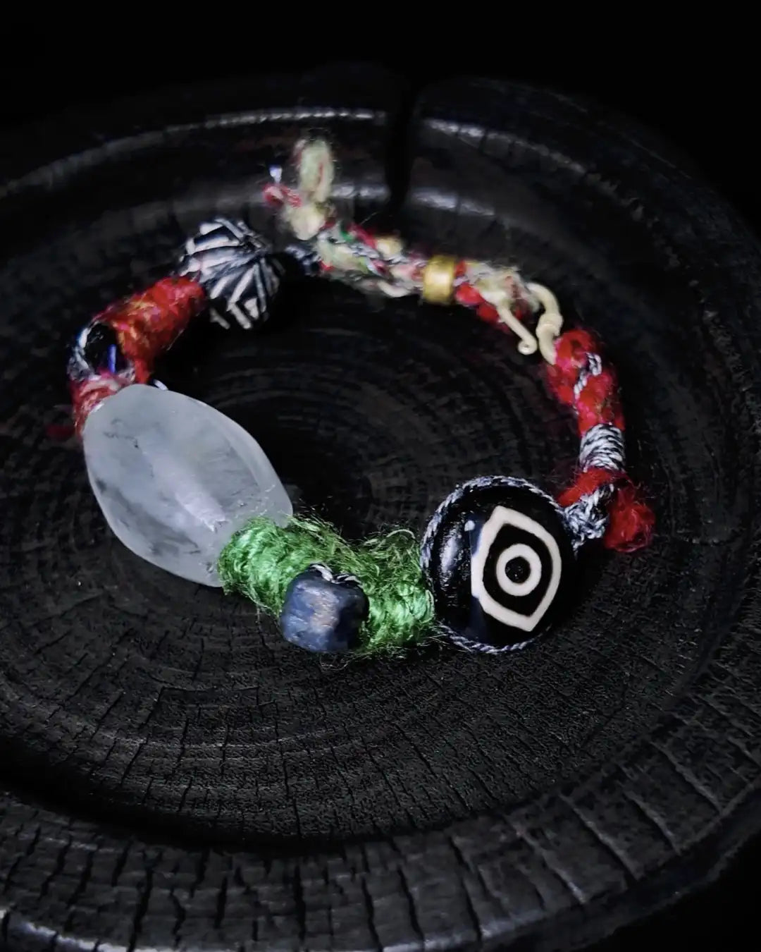 The Shaman #10 bracelet arranged in a dark charred-wood bowl