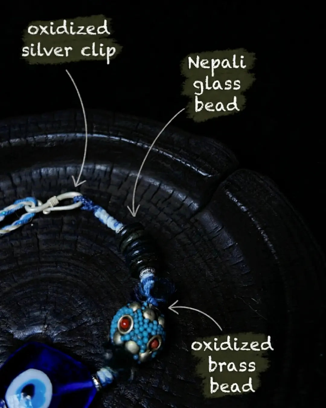 Closure detail of The Sentinel #15 — labelled oxidized silver clip, Nepali glass bead, and oxidized brass beaded bead at the clasp end