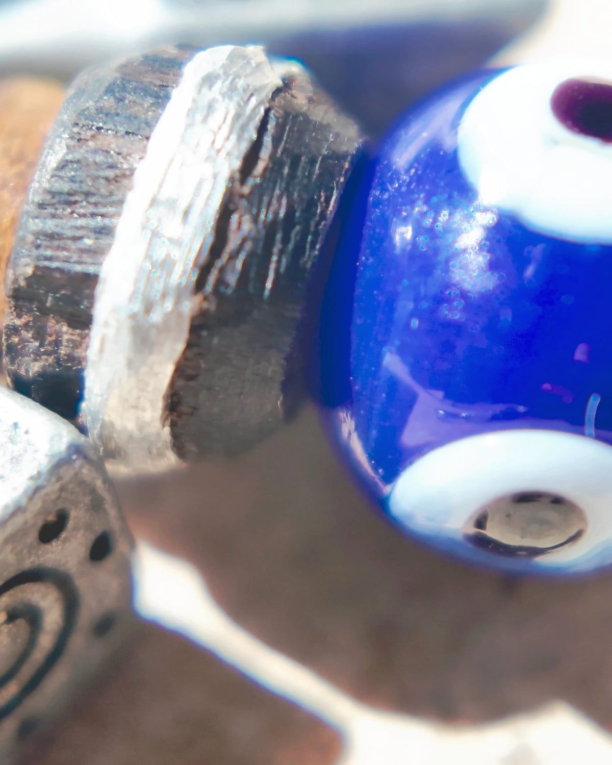 The Bluewatch #56: Silver-inlaid ebony bead beside the cobalt-blue evil-eye glass
