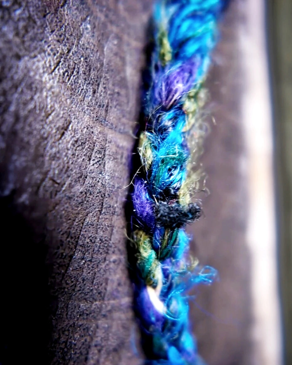 Close view of the blue-green Nepali banana-silk wrapping along the upper cord