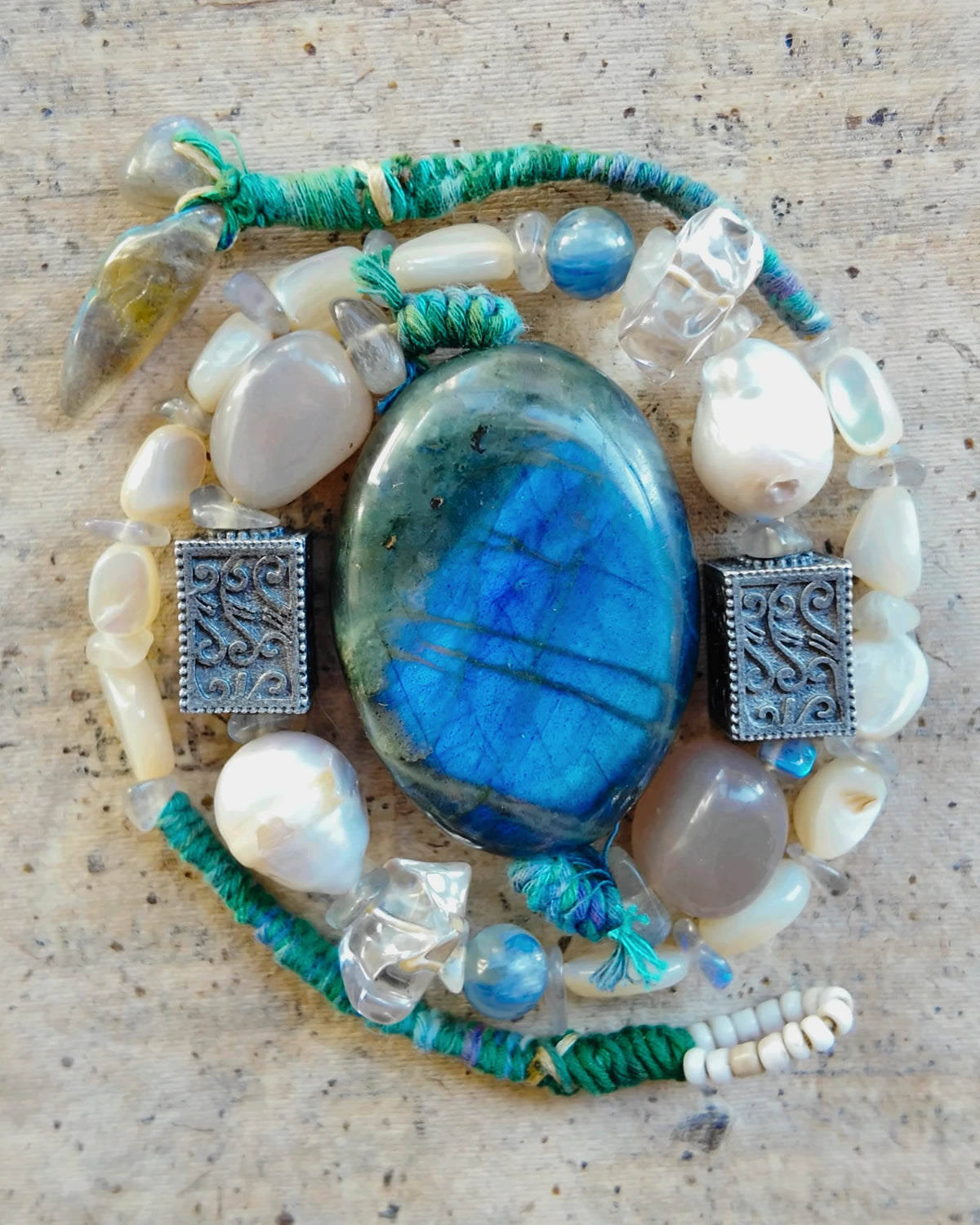 The Moonwake #44 coiled to show its labradorite, pearl and teal cord construction