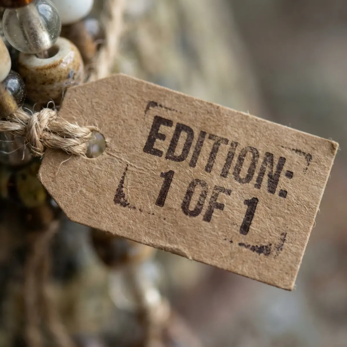 A finished talisman with its hand-stamped edition tag