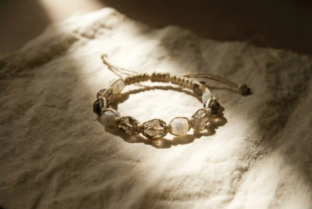 Cream hand-knotted clear quartz wrap bracelet by à la luck on linen — featured image for the Energy Muse alternatives buyer guide of handmade crystal jewelry brands
