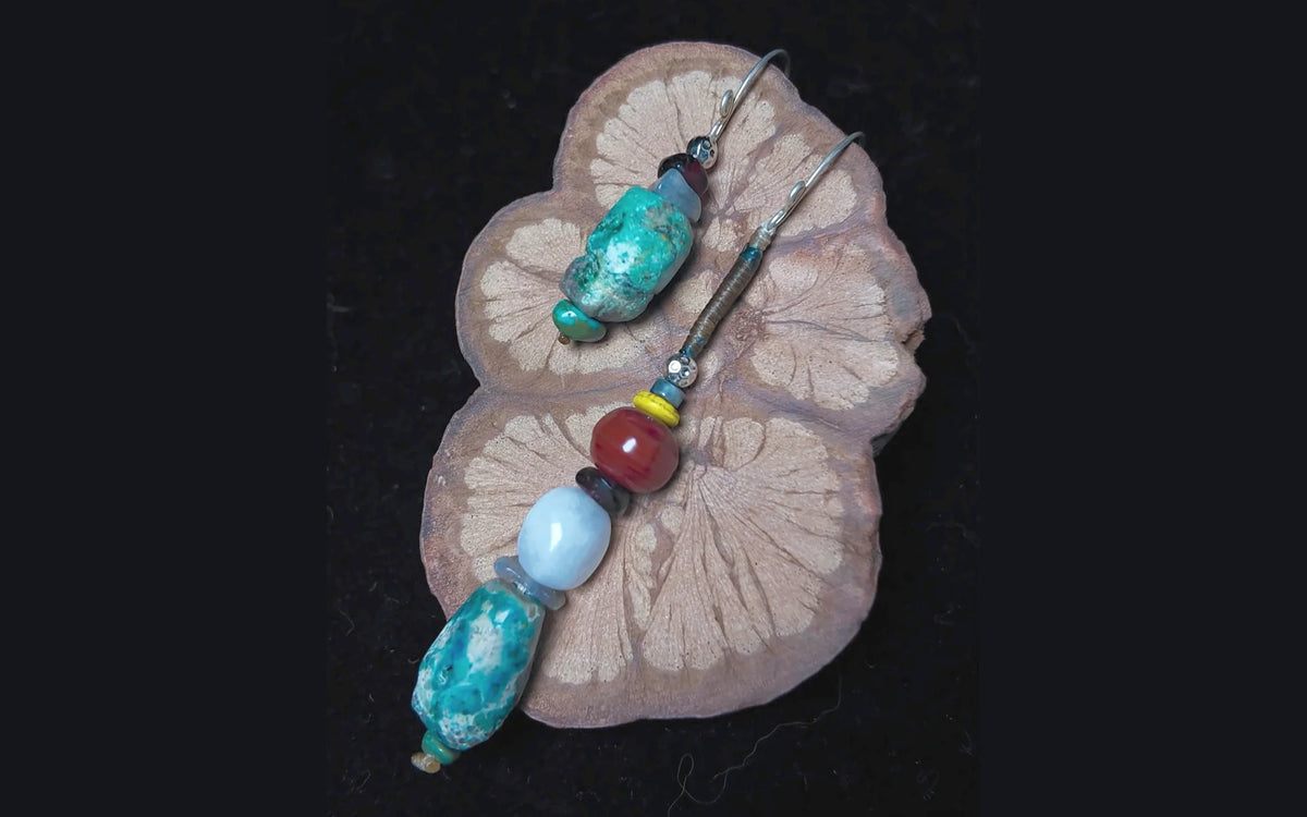 The Counterpoint #38 mismatched raw Turquoise earrings, short and long sides shown together on patterned wood