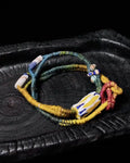 Colorful woven bracelet on a textured black surface