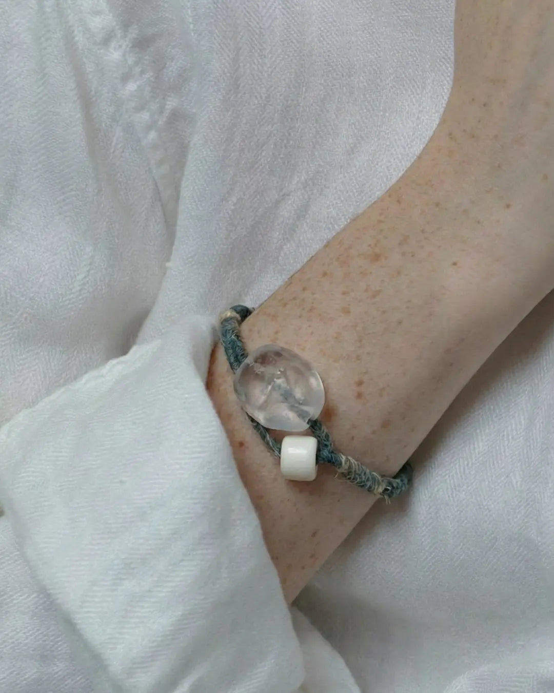 The Zen #08 patina glass bead energy bracelet by à la luck — worn on the wrist showing the Himalayan weathered glass bead centerpiece and bodhi bead on plant-dyed cotton thread and hemp cord.