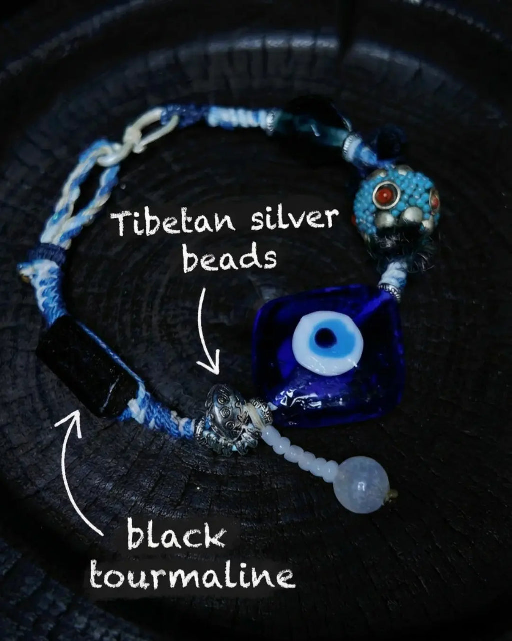 Material detail from The Sentinel #15 — labelled Tibetan silver beads and raw black tourmaline rod woven into the hand-knotted body