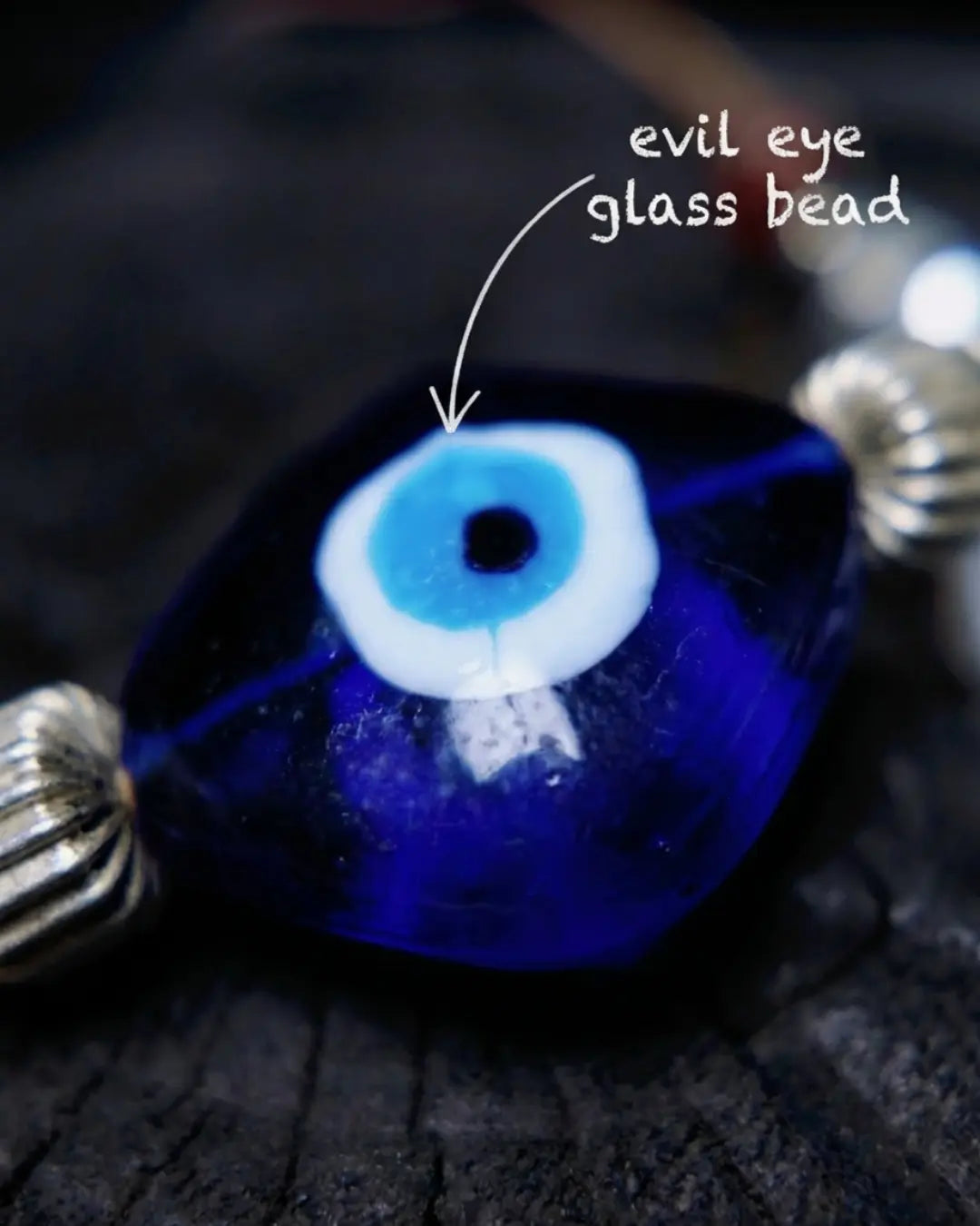 Material map for The Seer #19 — labelled evil eye glass beads, raw sapphire stone, and Tibetan-style alloy used in the hand-knotted necklace