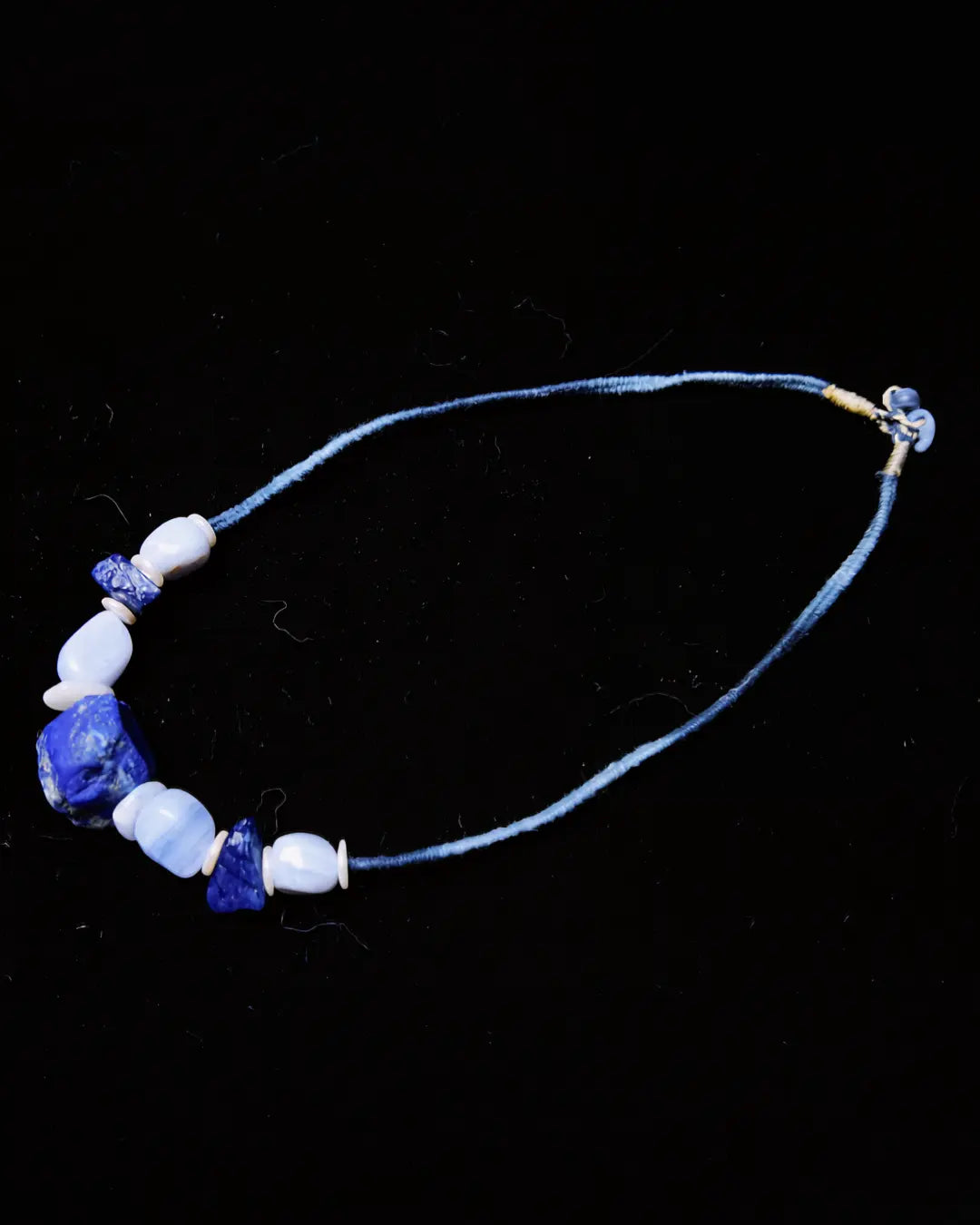 The Visionary #21 raw lapis lazuli clarity necklace shown flat on black — full edition-of-one necklace by à la luck with cotton-wrapped cord