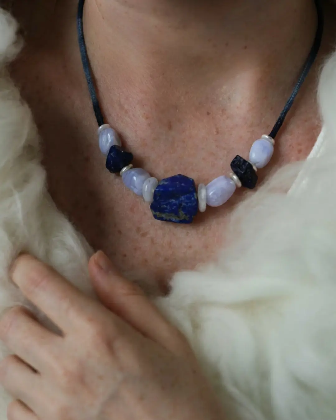 The Visionary #21 raw lapis lazuli clarity necklace by à la luck — worn at the neckline against a fleece collar