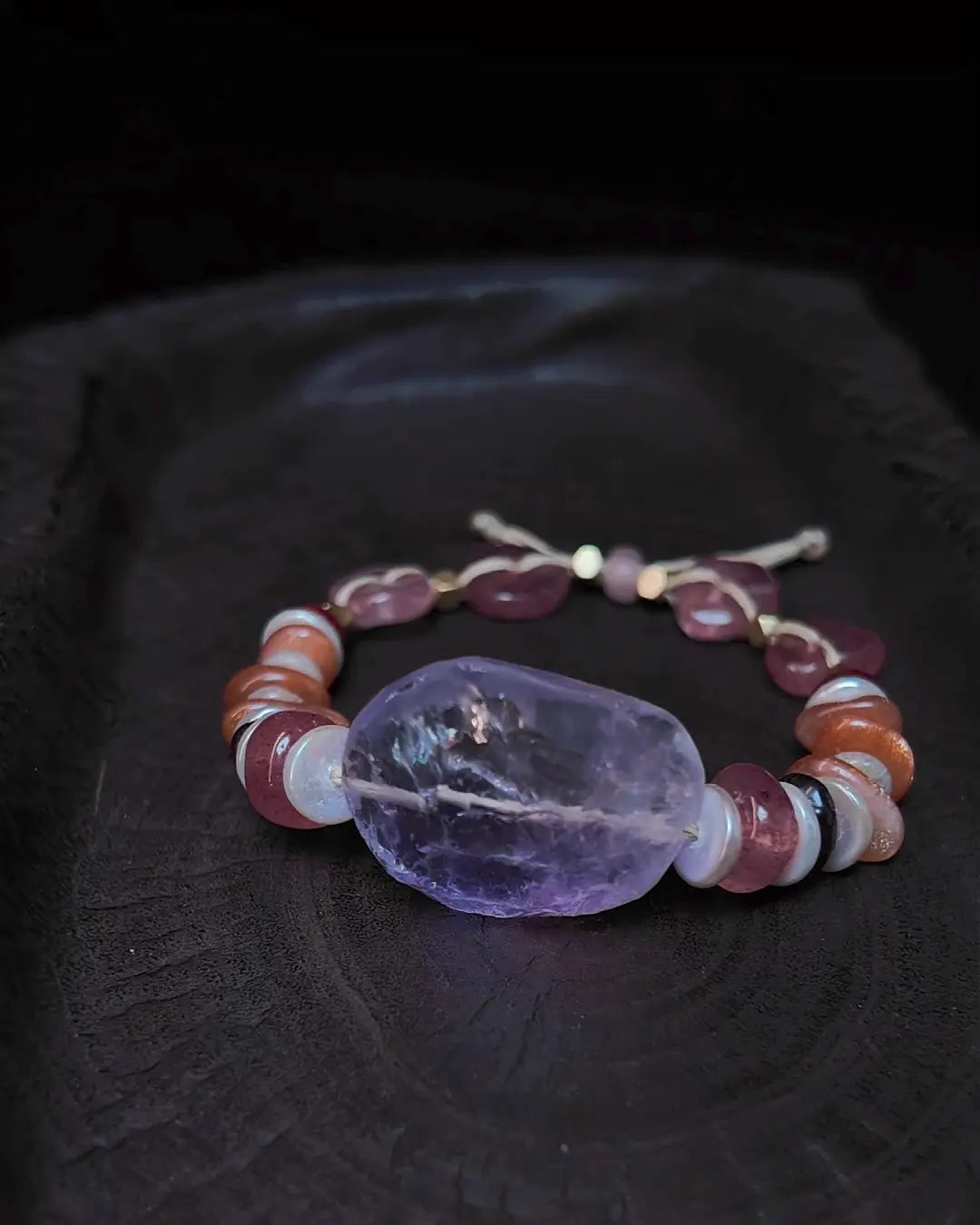 The Mystic #23 amethyst quartz bracelet, angled full view showing polished 29mm focal stone and complete bead stack