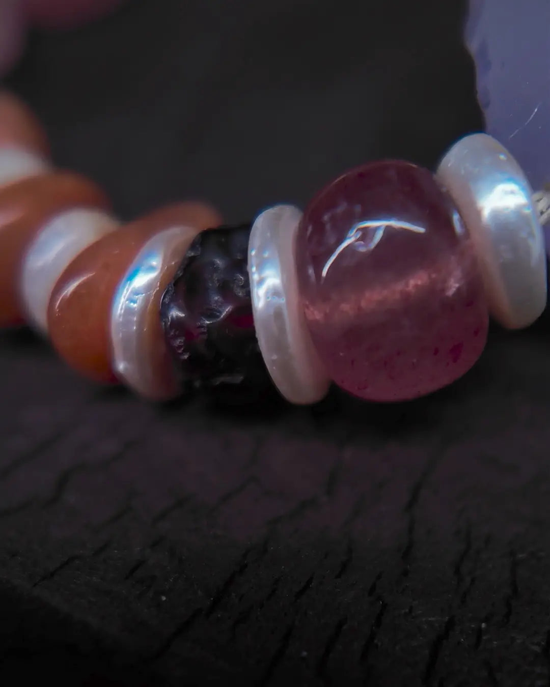Strawberry quartz and mother-of-pearl spacer side detail showing bead-knot construction