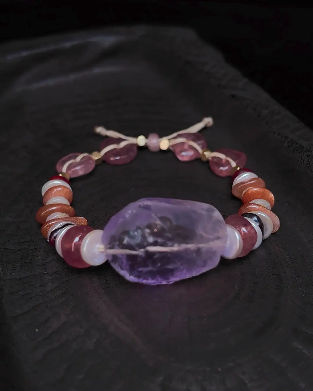 The Mystic #23 amethyst quartz bracelet, full flat lay on dark wood surface