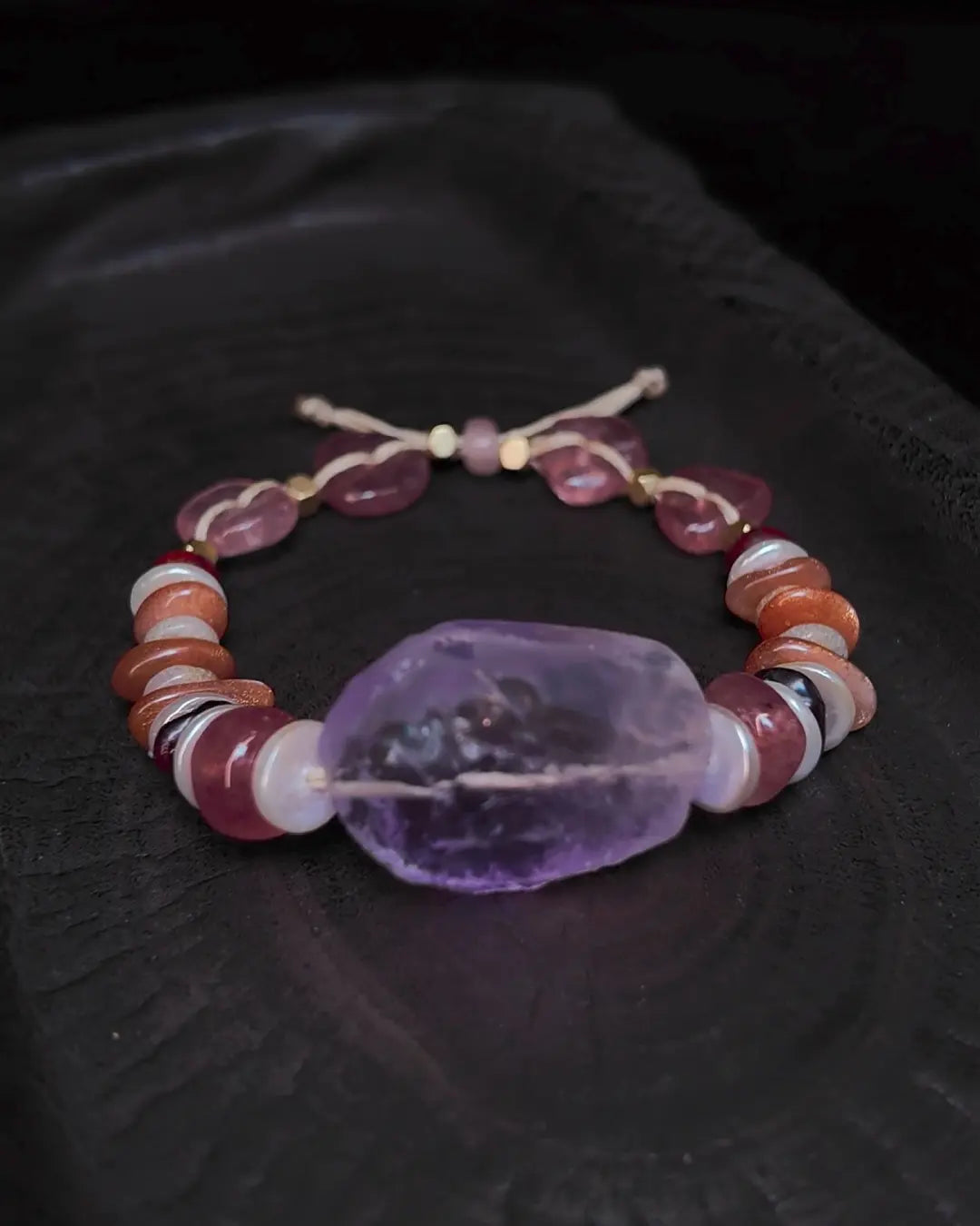 The Mystic #23 amethyst quartz bracelet, full flat lay on dark wood surface