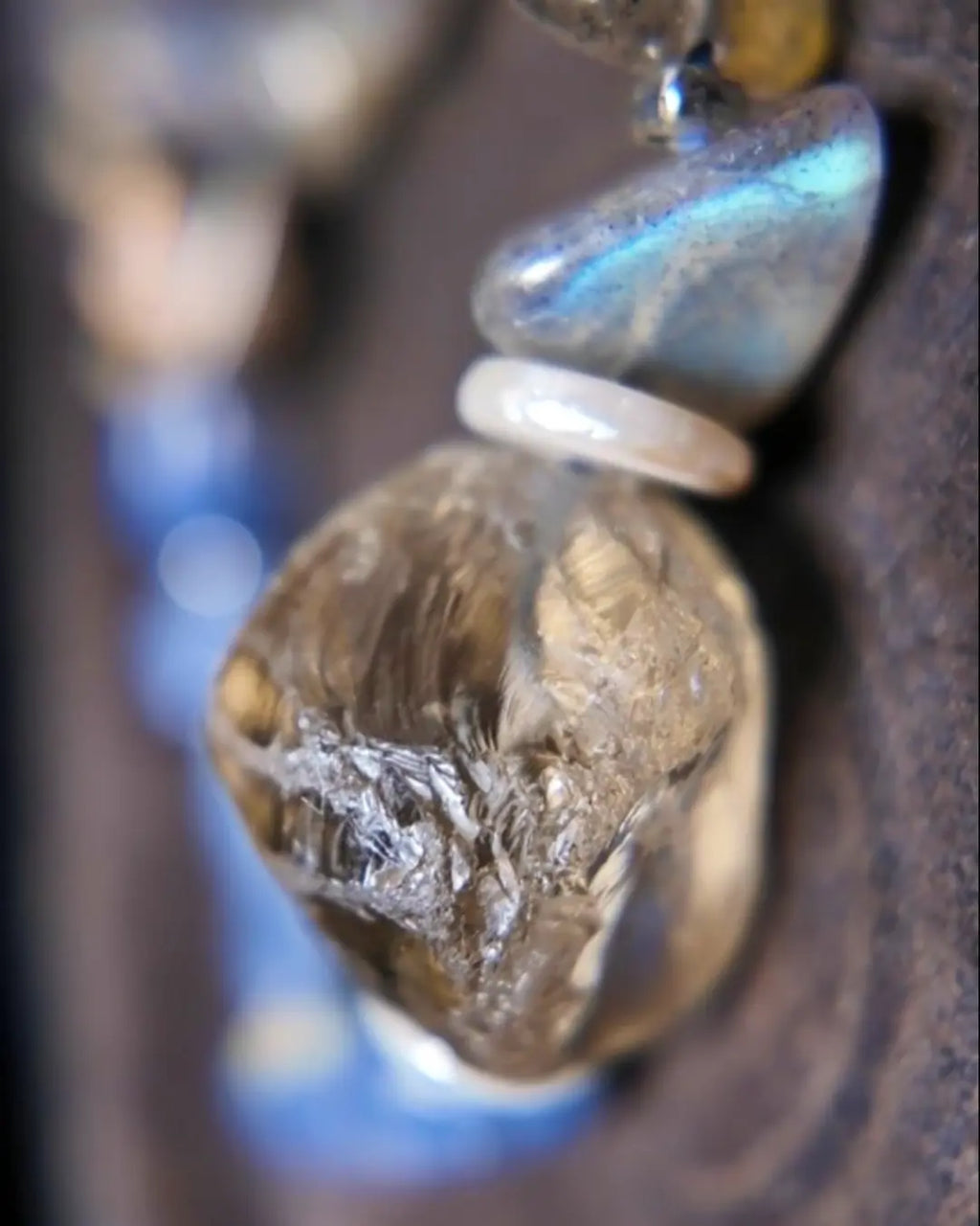 Macro detail of polished smoky quartz focal stone with internal phantom inclusions, paired with labradorite showing blue labradorescence
