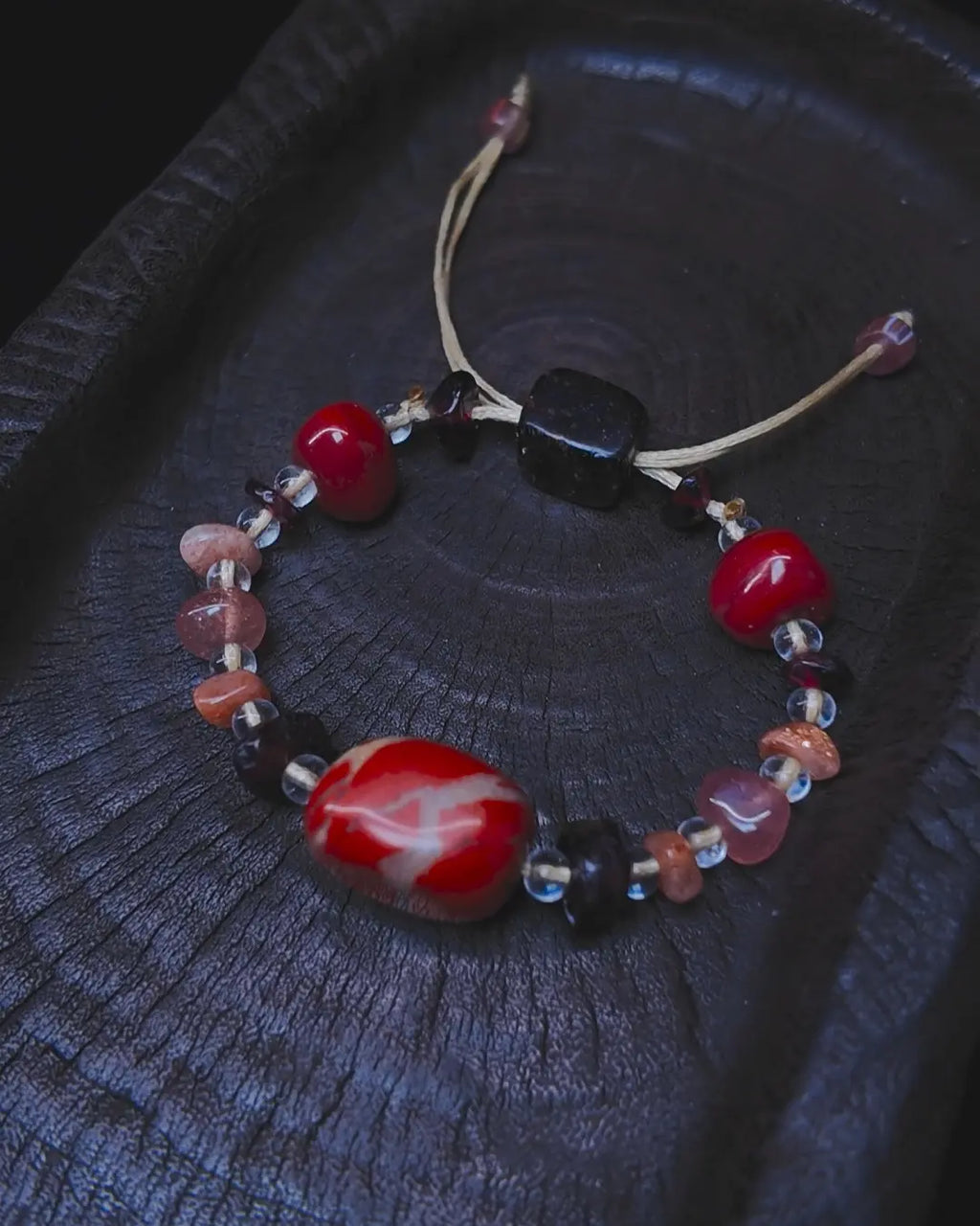 The Hearth #25 bracelet, full flat lay on dark wood surface showing complete bead arrangement