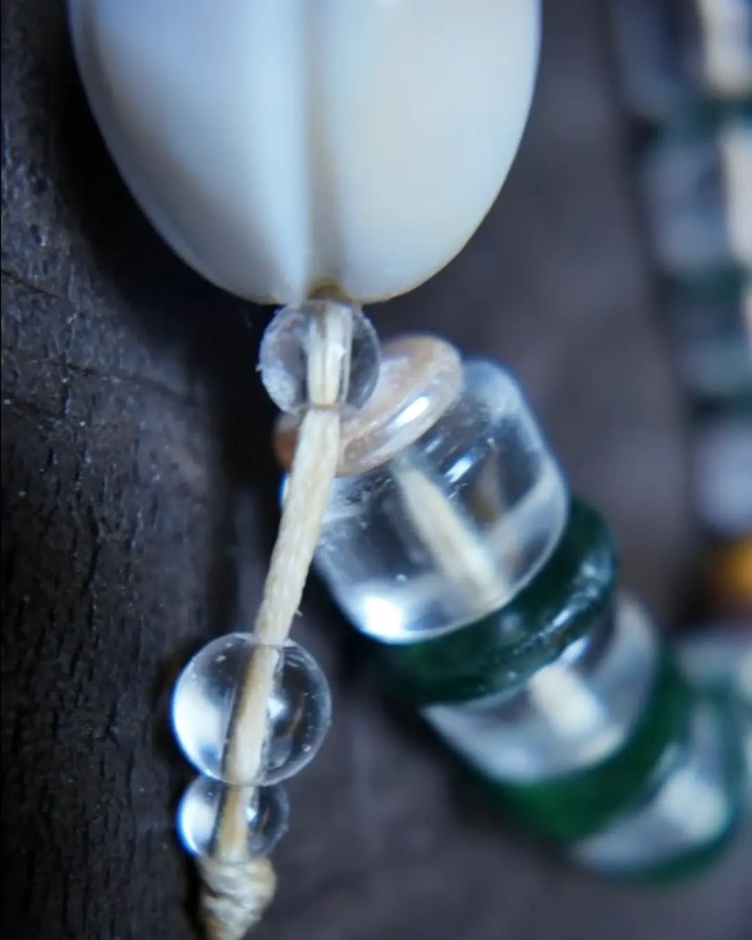 Macro of the sacred conch attachment, clear quartz and waxed cord in The Vow #26