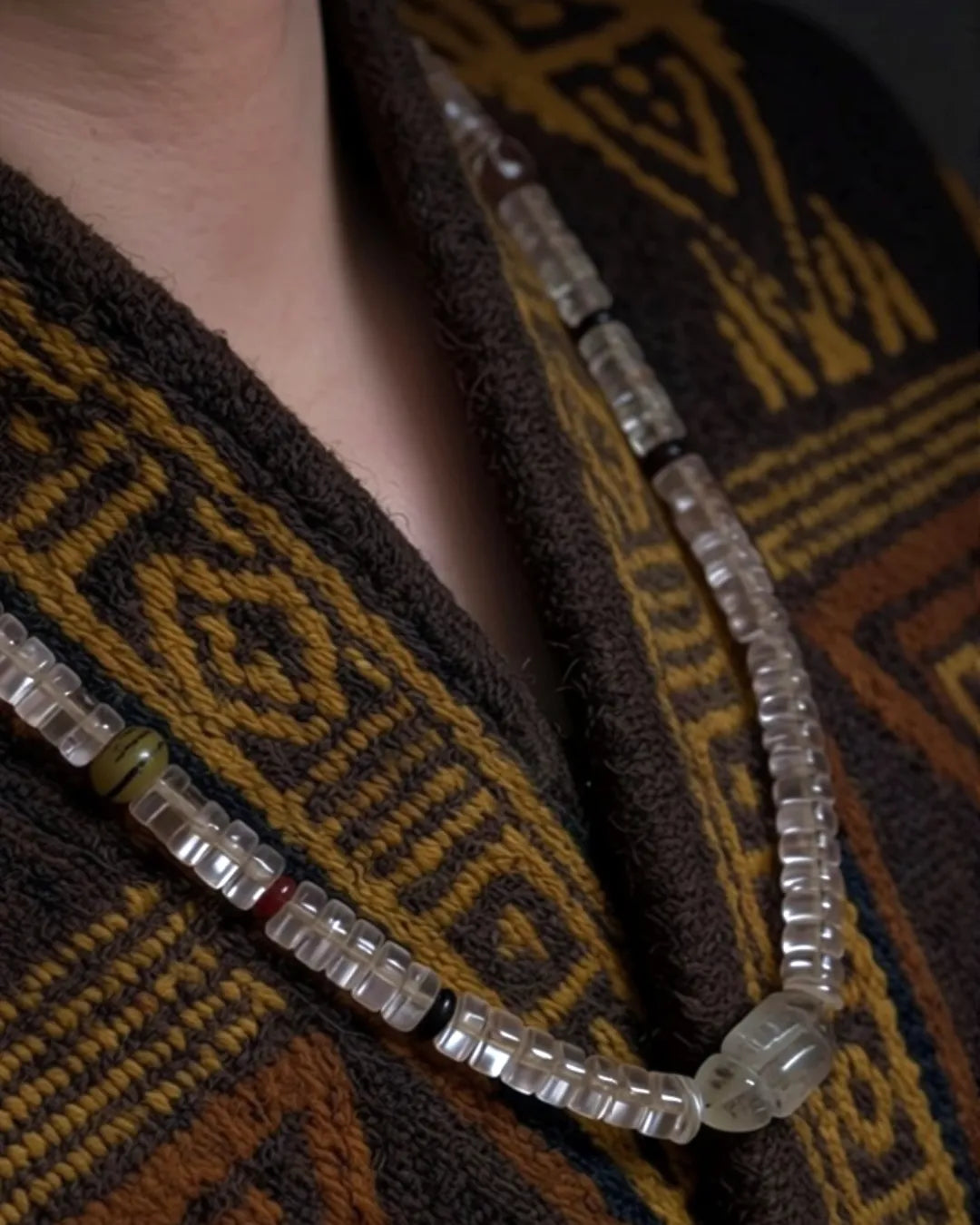 The Adept #27 necklace, full flat lay on dark wood surface showing complete bead arrangement
