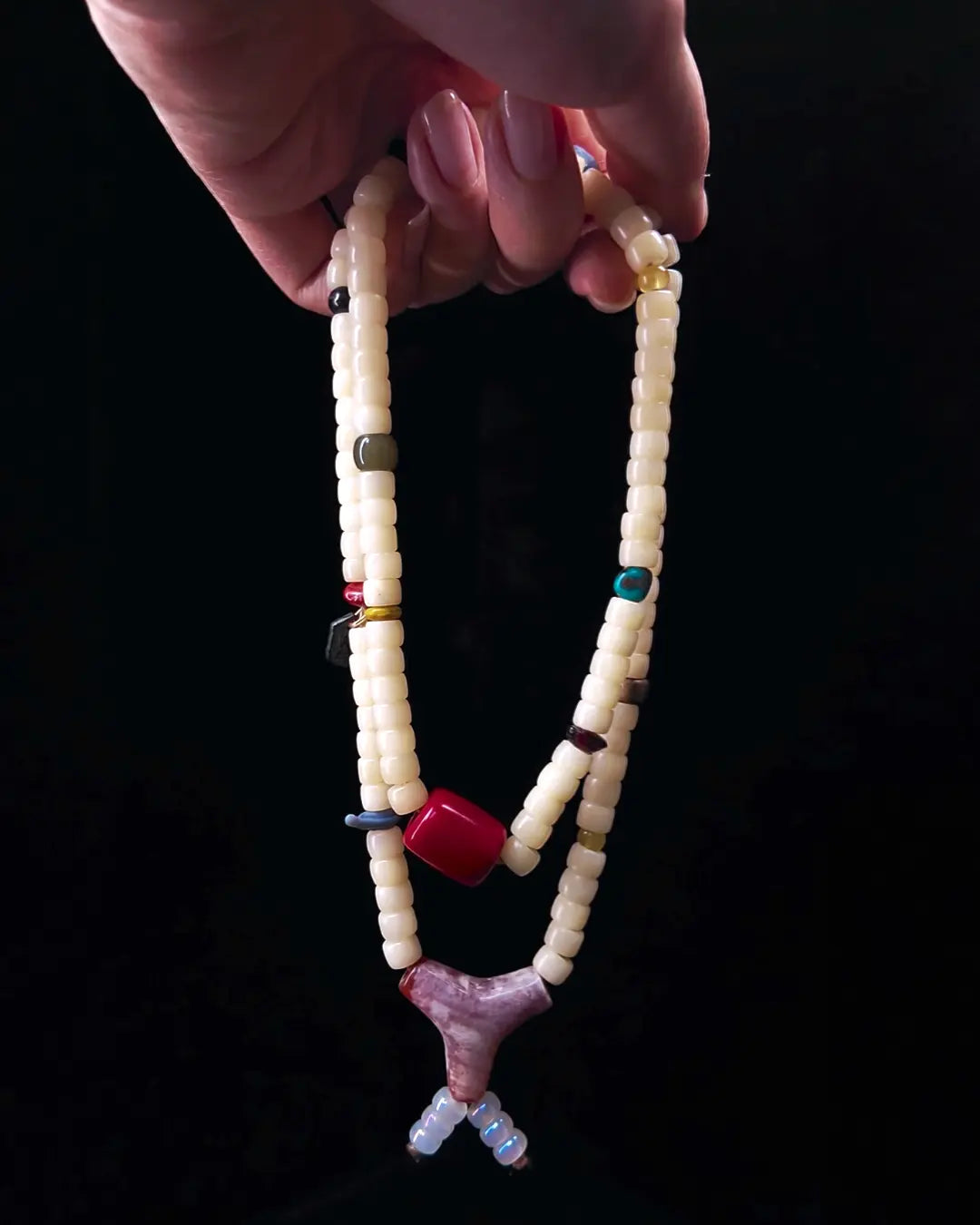 The Spark #29 necklace, hero lifestyle shot featuring bamboo coral, approx 16mm