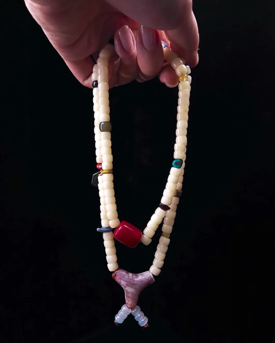The Spark #29 necklace, hero lifestyle shot featuring bamboo coral, approx 16mm