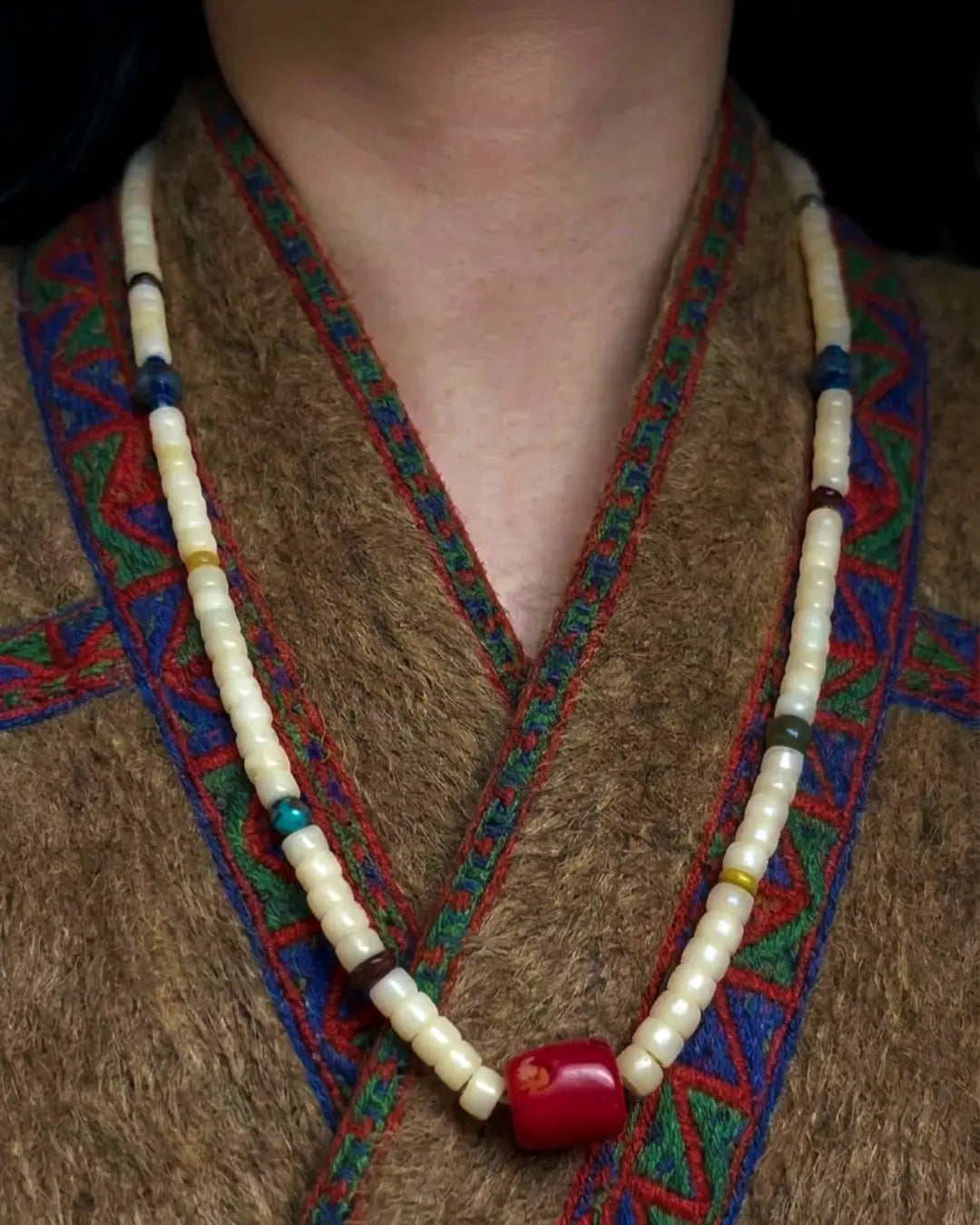 The Spark #29 necklace, full flat lay on dark wood surface showing complete bead arrangement