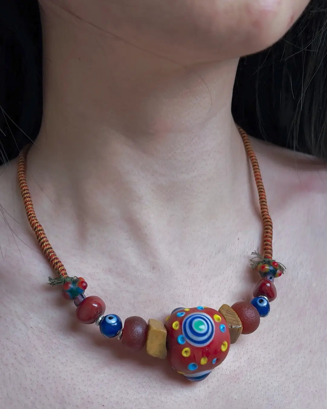 The Aegis #30 dragonfly eye protection necklace, detail view 4 — showing evil eye glass, patina red agate, and Tibetan silver accents