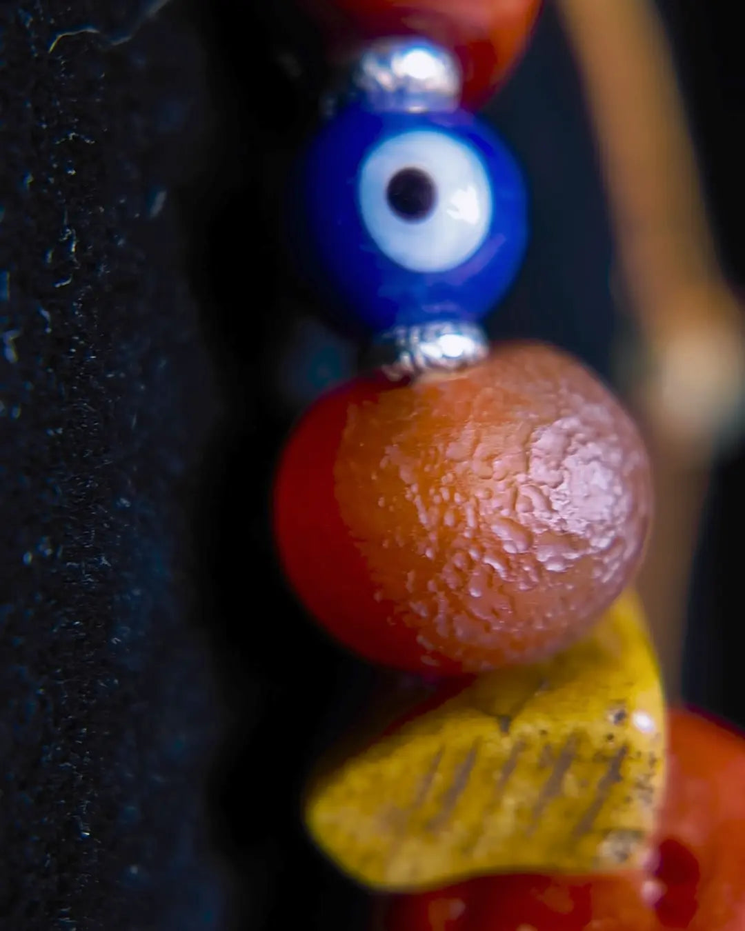 The Aegis #30 dragonfly eye protection necklace, detail view 5 — showing evil eye glass, patina red agate, and Tibetan silver accents