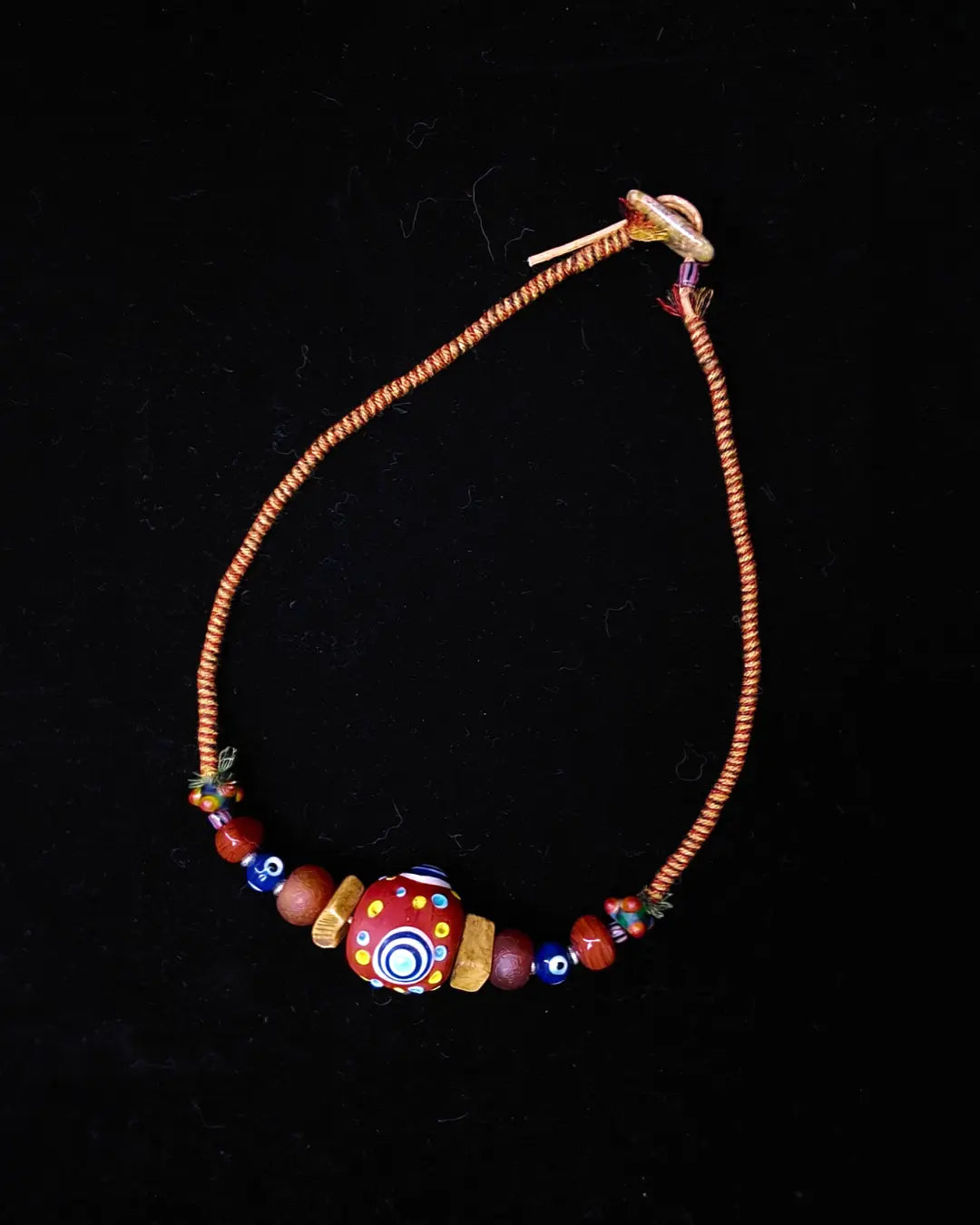 The Aegis #30 dragonfly eye protection necklace, closure detail showing unakite toggle and sliding-knot finish