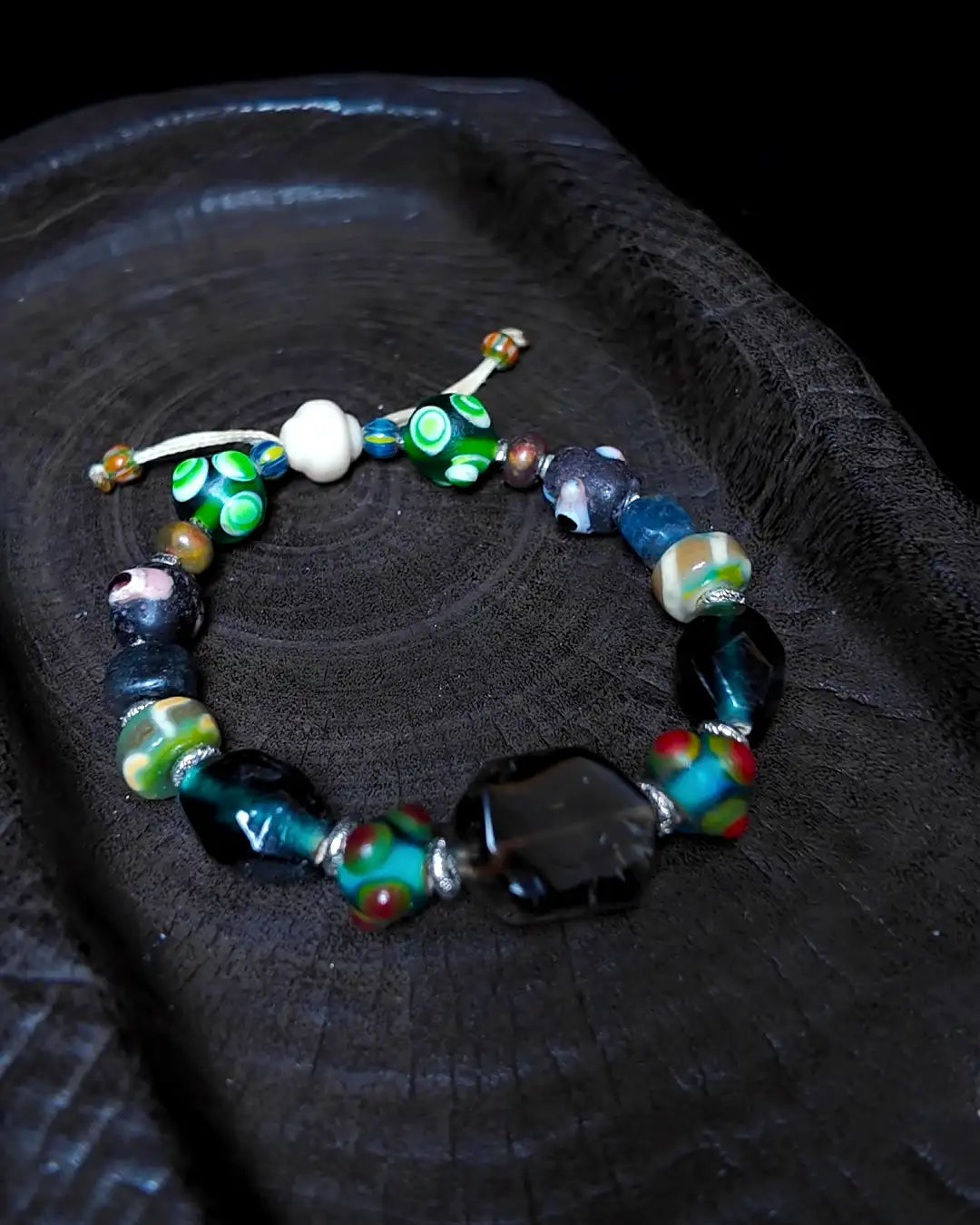 The Warden #32 smoky quartz and Tibetan dzi protection bracelet, closure detail showing silicified wood lantern bead and sliding-knot finish