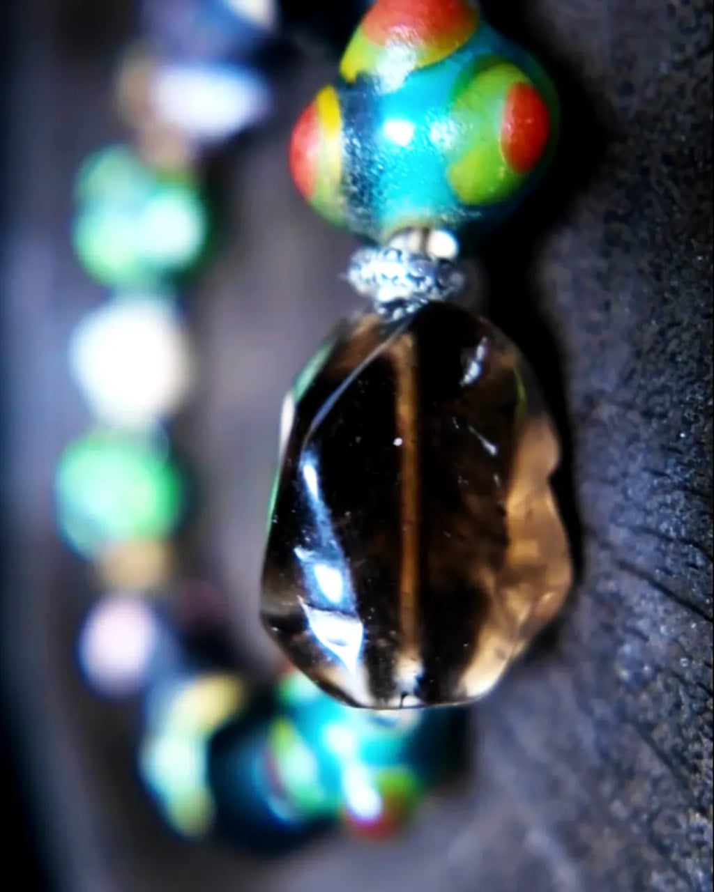 Macro detail of 20mm Himalayan old-mine smoky quartz faceted nugget focal and Tibetan dzi fragment agate bead