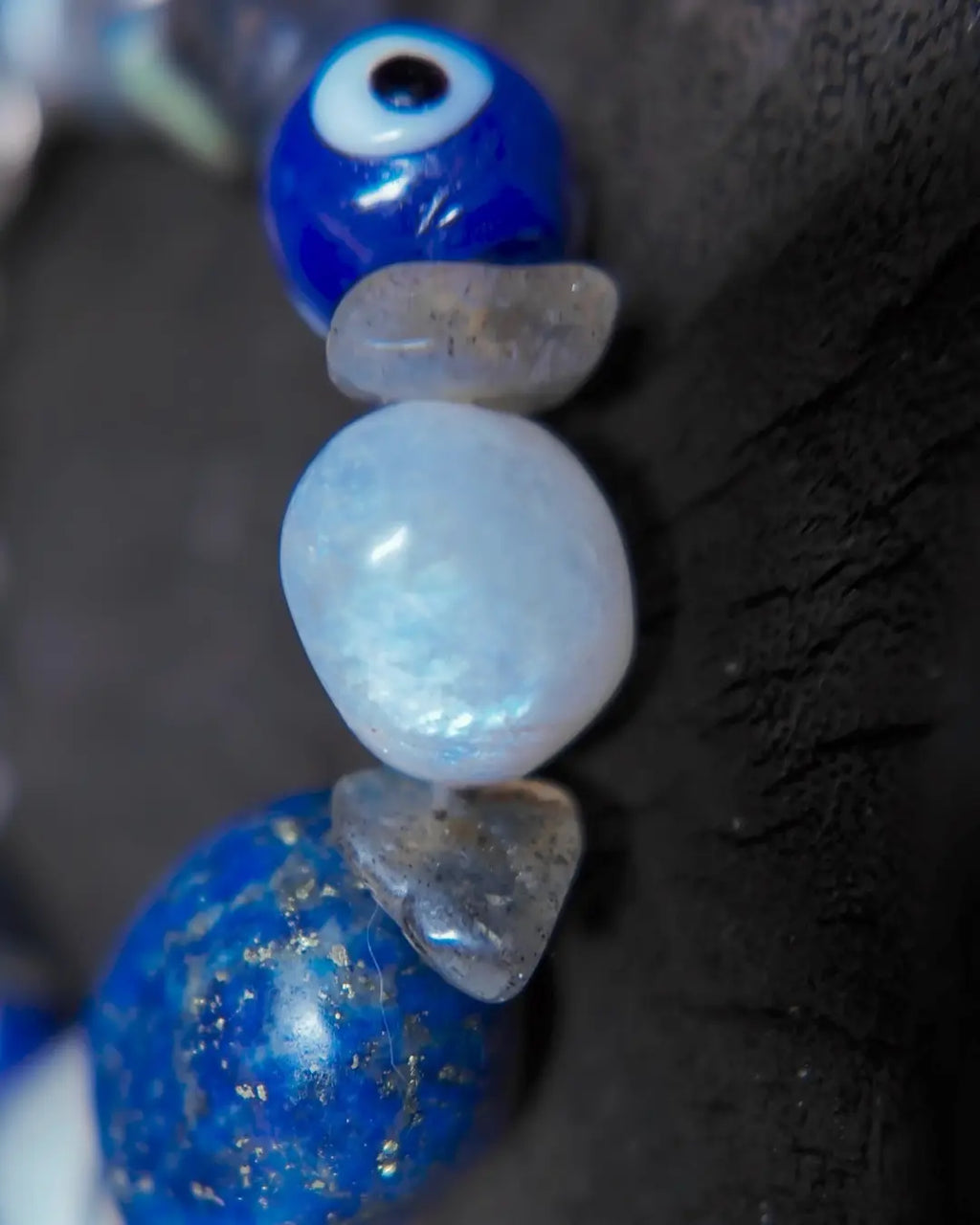 The Augur #33 lapis lazuli and blue moonstone vision bracelet, detail view 4 — showing raw sapphire, labradorite, clear quartz, and evil eye glass accents