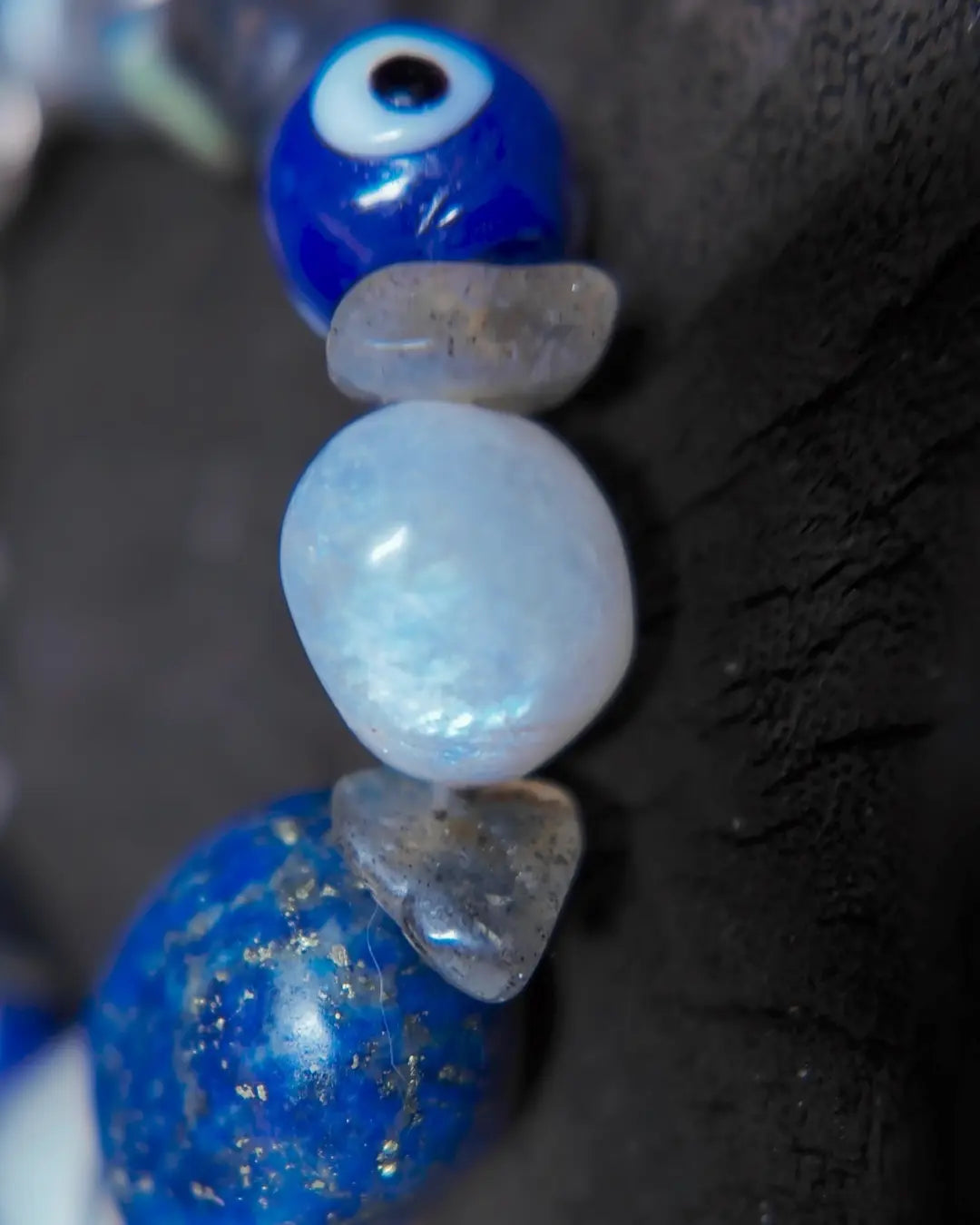The Augur #33 lapis lazuli and blue moonstone vision bracelet, detail view 4 — showing raw sapphire, labradorite, clear quartz, and evil eye glass accents