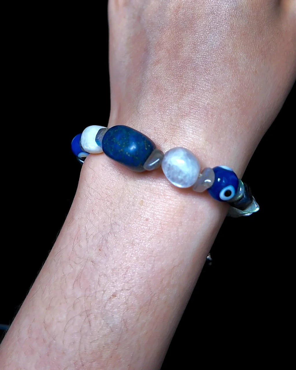 The Augur #33 lapis lazuli and blue moonstone vision bracelet, detail view 5 — showing raw sapphire, labradorite, clear quartz, and evil eye glass accents