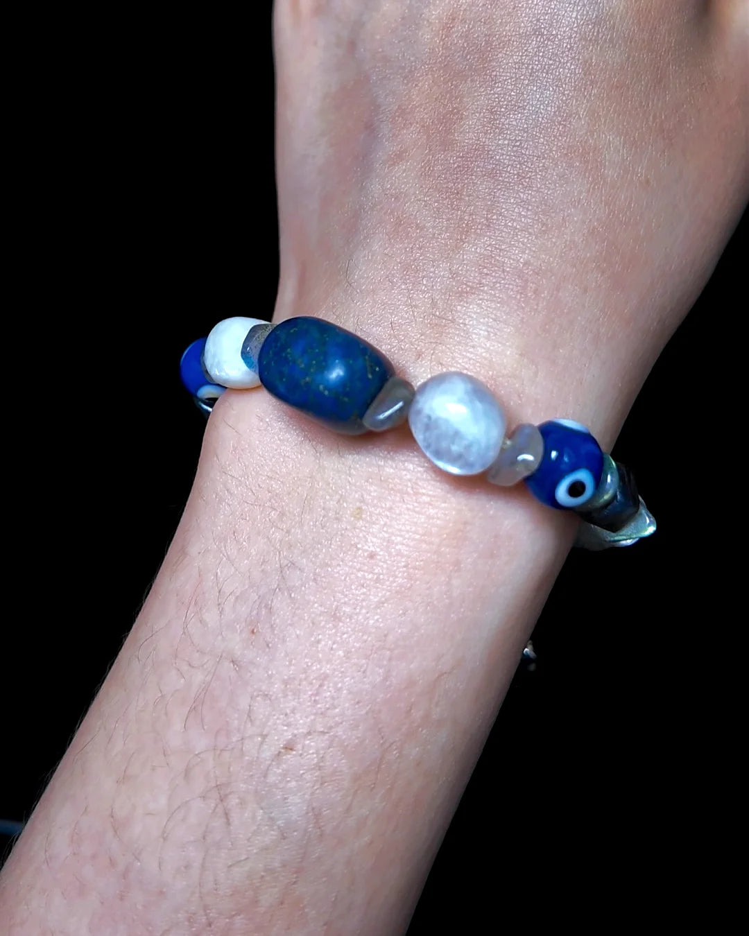 The Augur #33 lapis lazuli and blue moonstone vision bracelet, detail view 5 — showing raw sapphire, labradorite, clear quartz, and evil eye glass accents