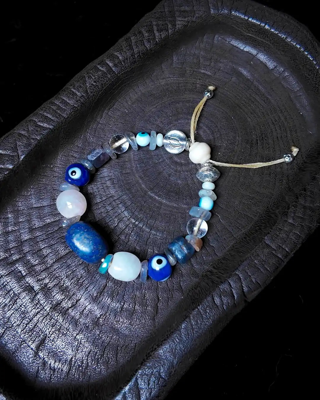 The Augur #33 lapis lazuli and blue moonstone vision bracelet, closure detail showing silicified wood lantern bead and sliding-knot finish
