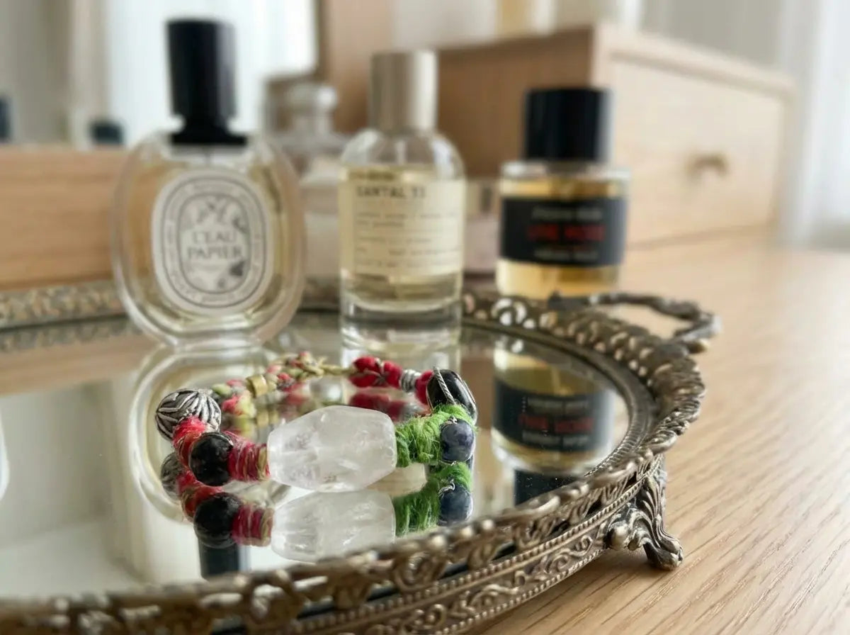Collection of perfume bottles and an energy bracelet on a reflective surface