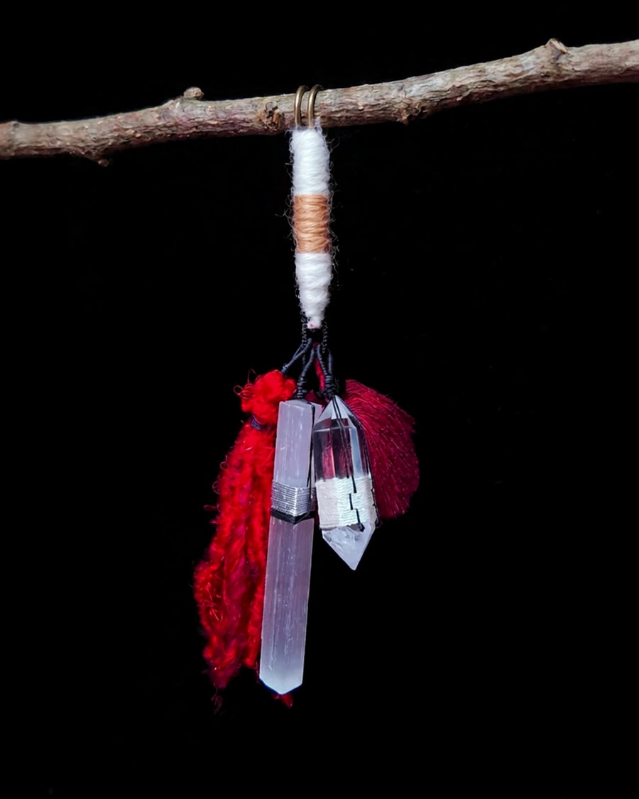 Full hanging view of The Beacon #41 with two crystal points, two red tassels and a brass pin