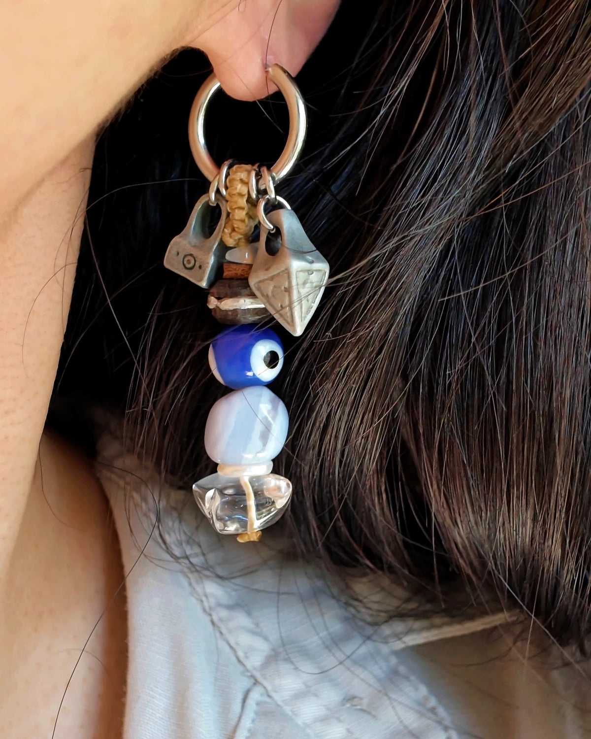The Bluewatch #56: Earring worn in profile, showing eye glass, blue lace agate, clear quartz and side charms