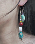 The Counterpoint #38 asymmetric raw turquoise earrings worn as a deliberate short-and-long pair