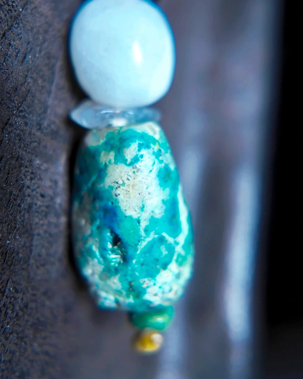 Macro detail of the untreated raw turquoise focal on the long earring