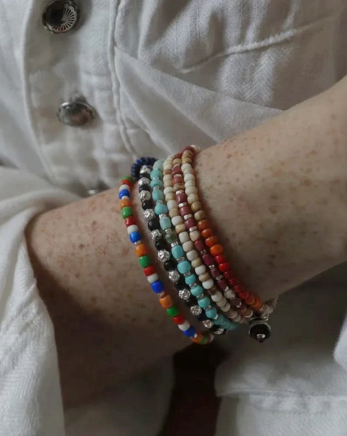 The Daybeads #46 six glass bracelets stacked with a linen shirt; sold individually