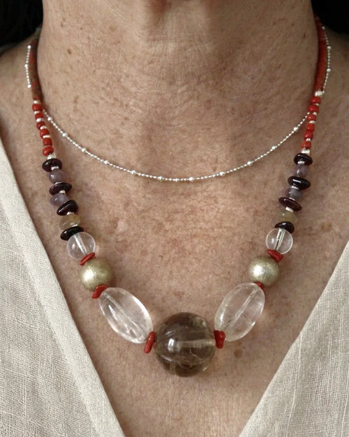 The Emberline #47 quartz necklace worn with linen; the separate fine chain is not included