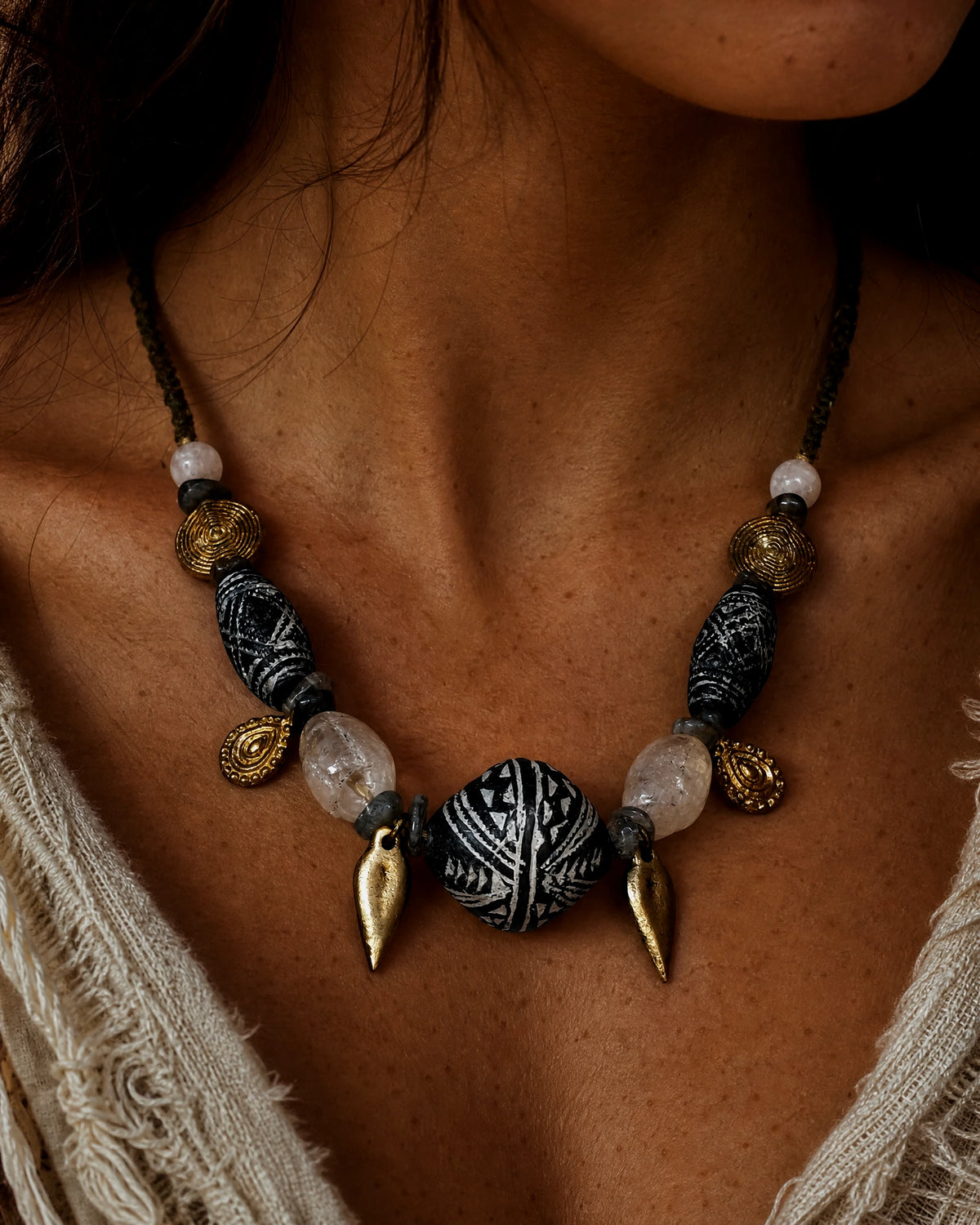 The Inkweave #59: Necklace worn with an open pale shirt, showing the carved clay focal and leaf drops