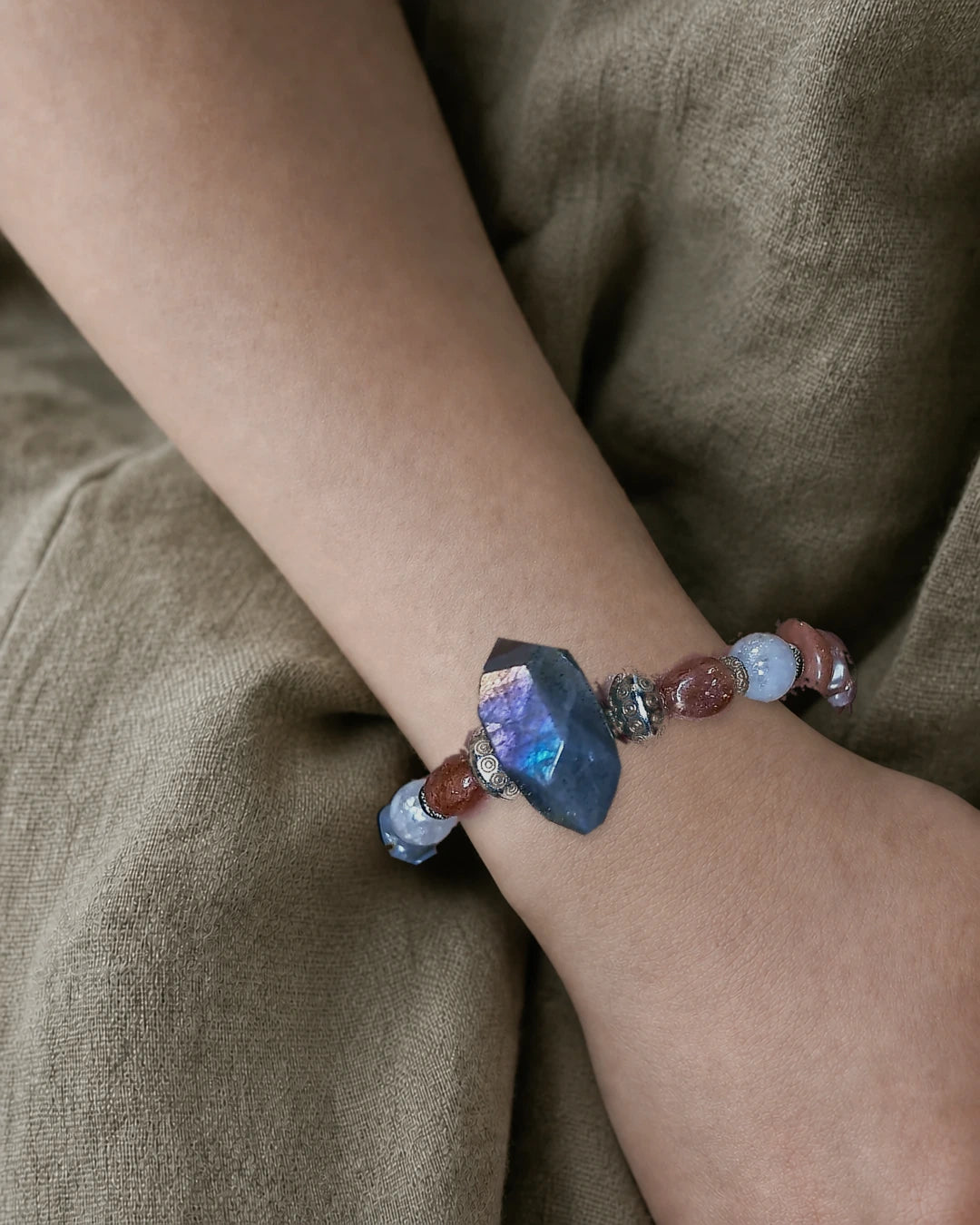 The Lucent #35 exact labradorite, sunstone, and blue moonstone bracelet worn on an editorial model wrist
