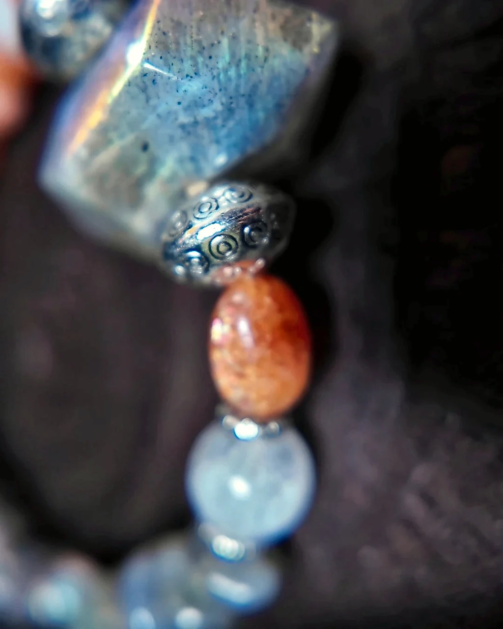 Macro detail of The Lucent #35 labradorite focal bead and antiqued metal accents