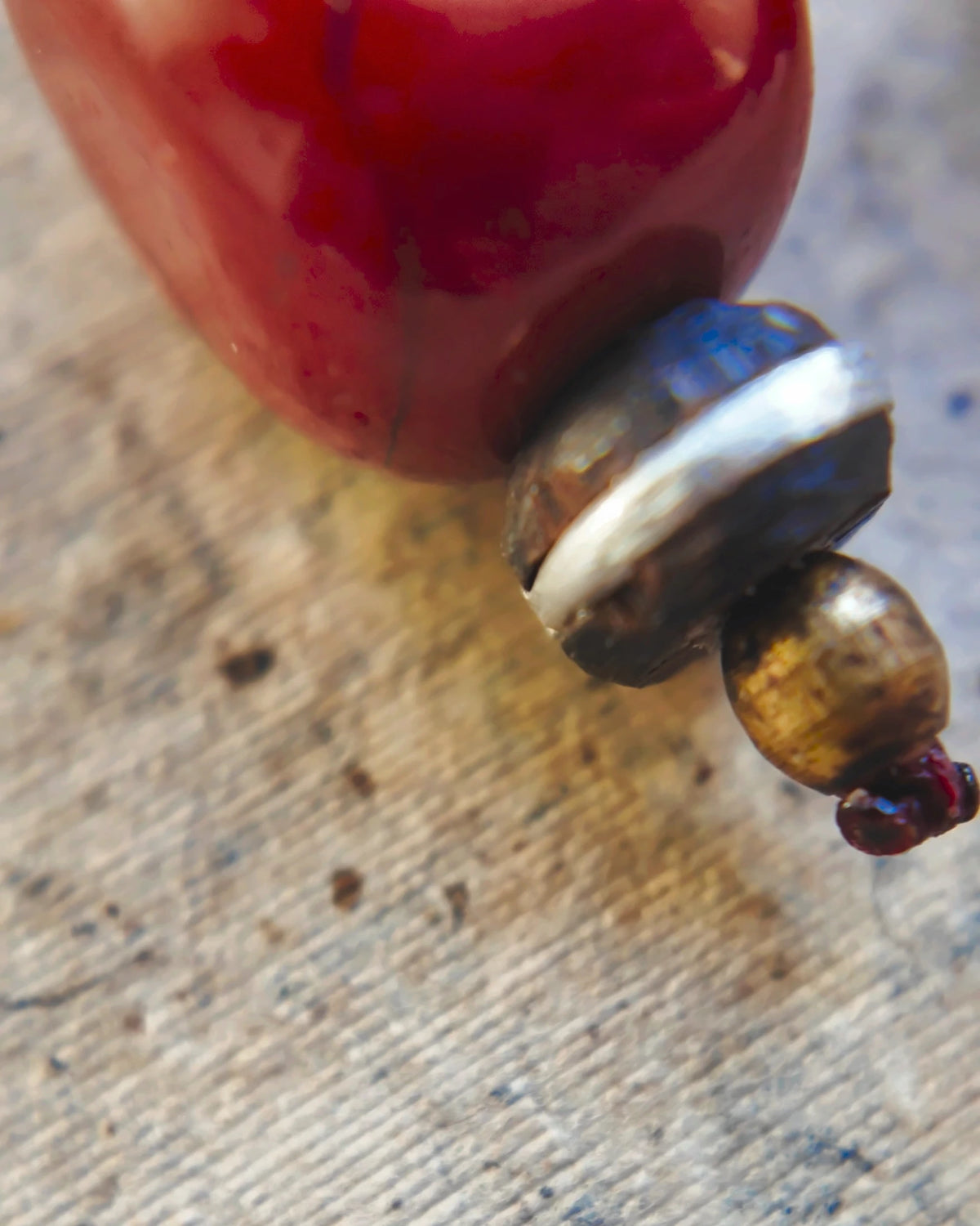 The Redthread #52: Ebony bead with silver inlay above the small brass bead