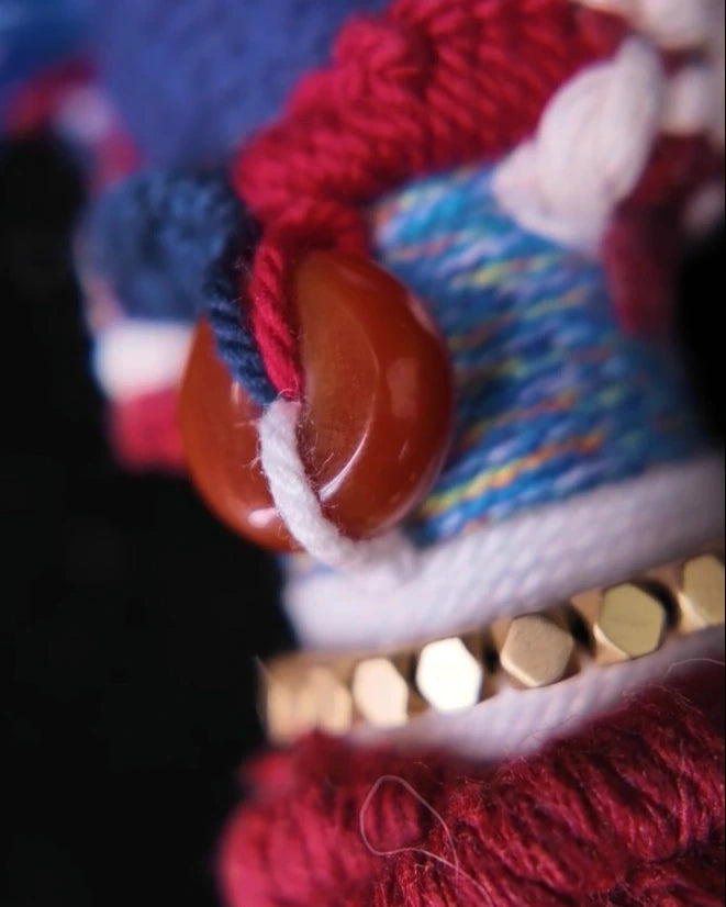 Close view of the 13.5 mm red-toned Hetian jade bead tied against the wrapped cotton body