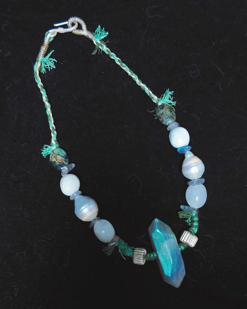 Full view of The Threshold #36 labradorite, pearl and moonstone choker on a dark background