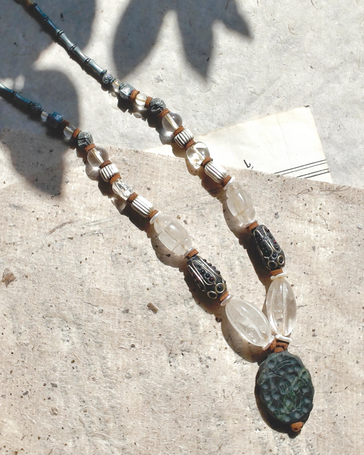 Quartz and decorative metal bead sequence with mother-of-pearl and leather spacers
